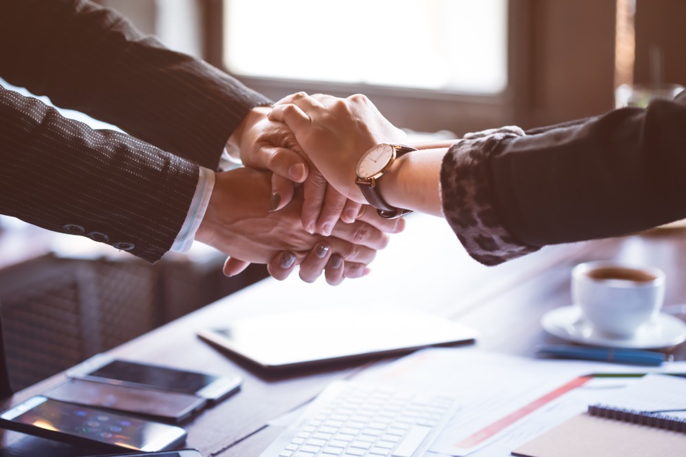 business-people shaking hands over a settlement agreement