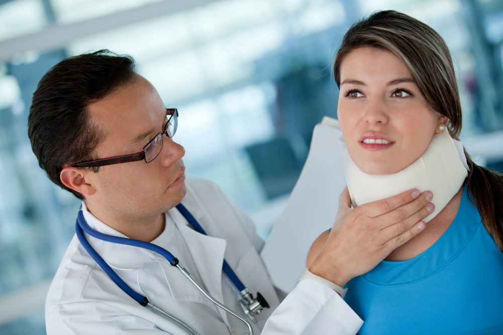 doctor helping a female patient with her surgical collar