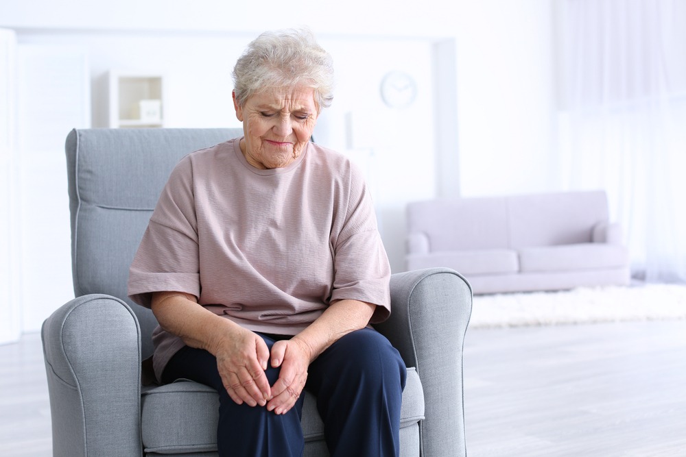 elderly woman rubbing her sore knee