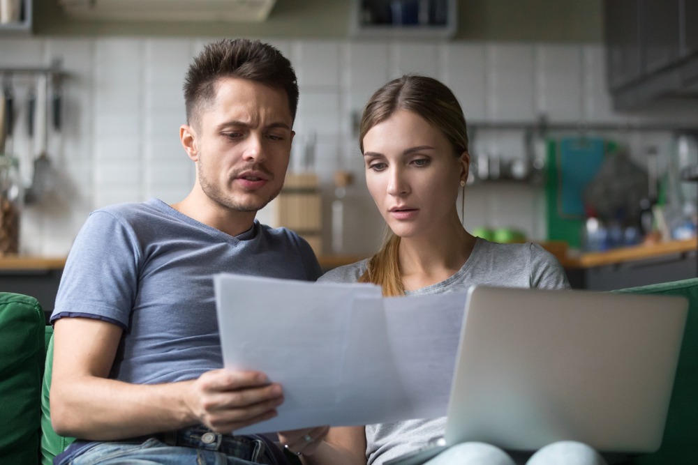 stressed young couple reviewing their finances