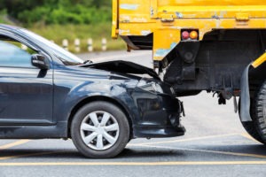 black car crashing into yellow truck