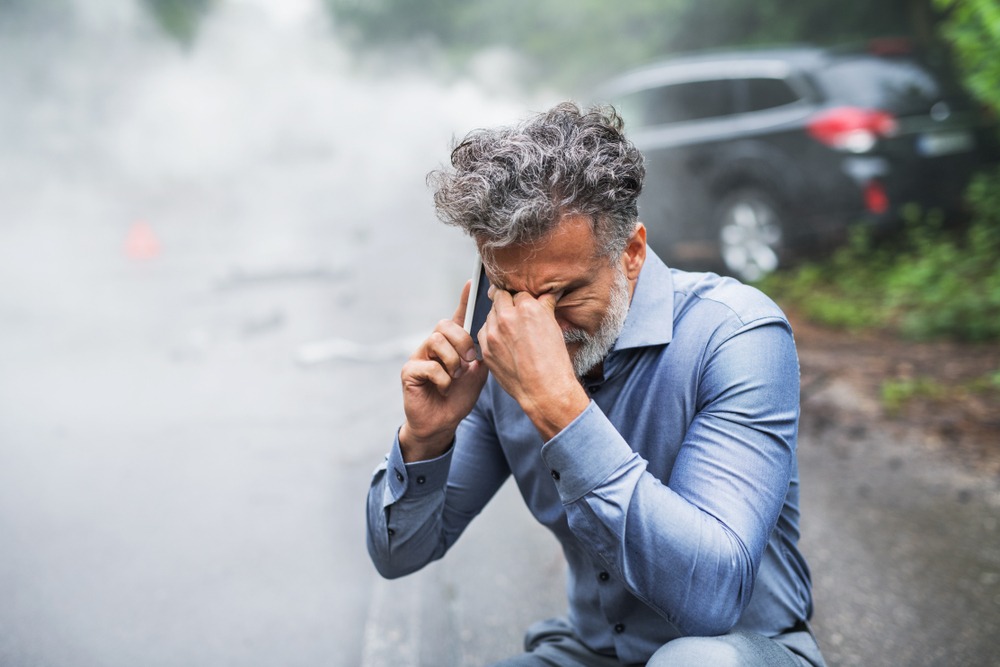 Man calling for help after a car accident, which is one of the most common causes of wrongful death.