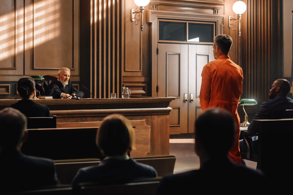 Person standing in front of a judge in a courtroom and wondering why they have to go to court after their car accident