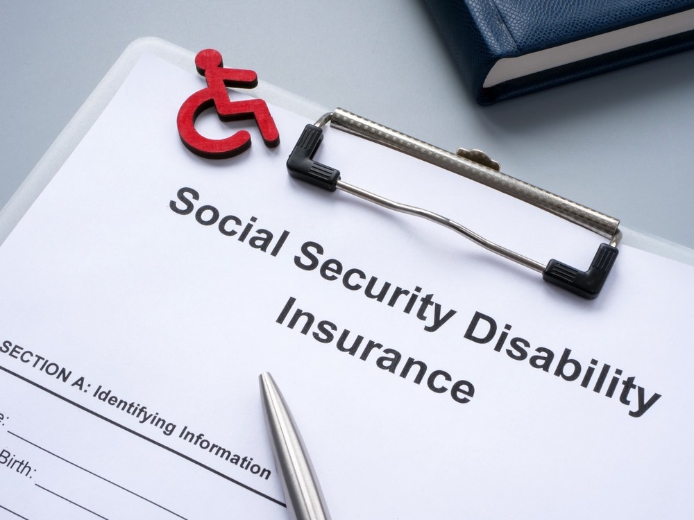 A clipboard with paperwork for SSDI benefits. A lawyer can explain how much SSDI is in North Carolina in 2026.