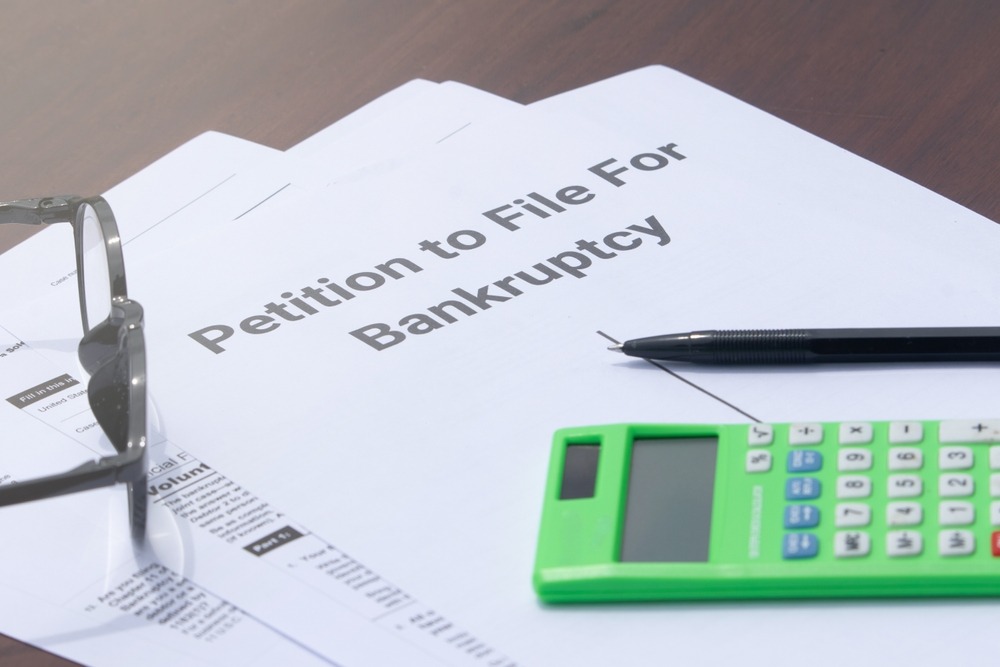 A pile of paperwork to file for bankruptcy. Talk to our team to learn how to hire the best bankruptcy lawyer.