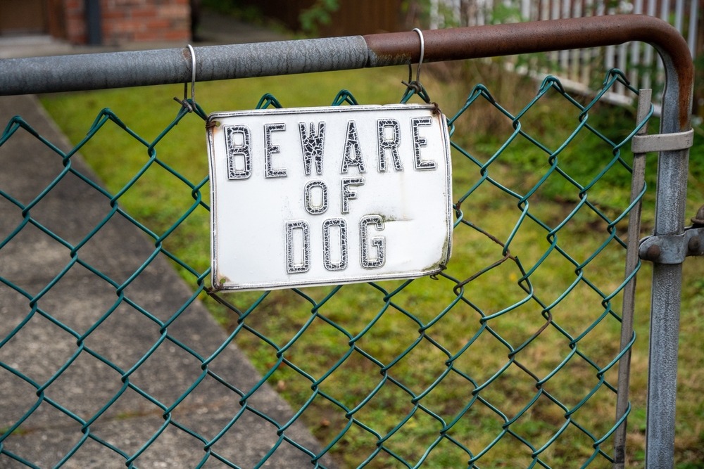 “Beware of dog” sign hung on a gate. What to do if a dog bites you?