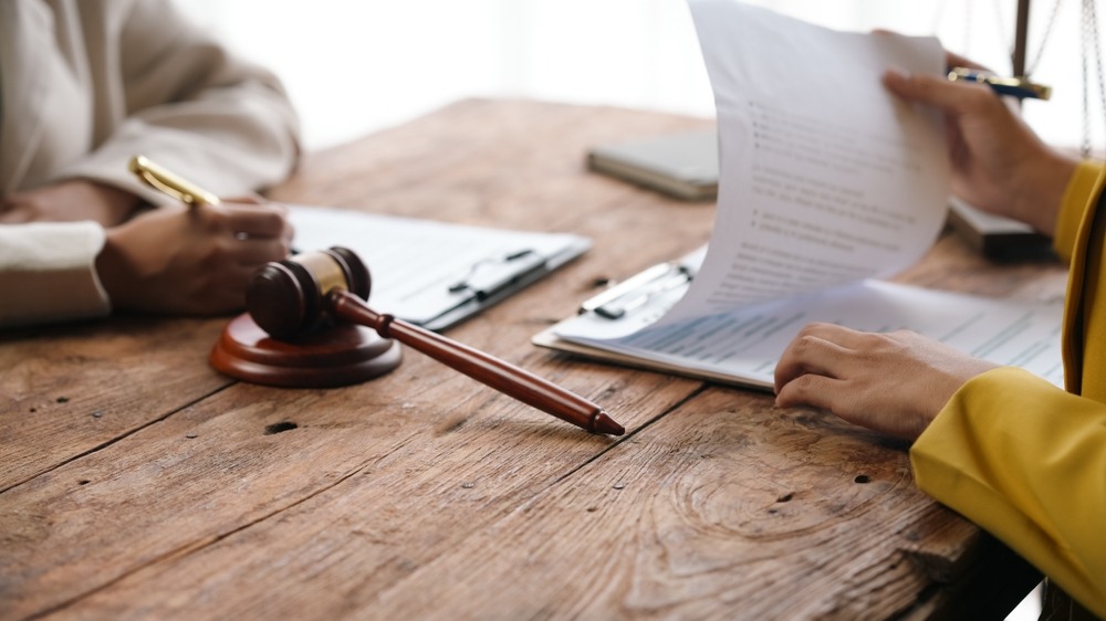 Two lawyers reviewing paperwork at a table. Learn about what to expect during a dog bite lawsuit.