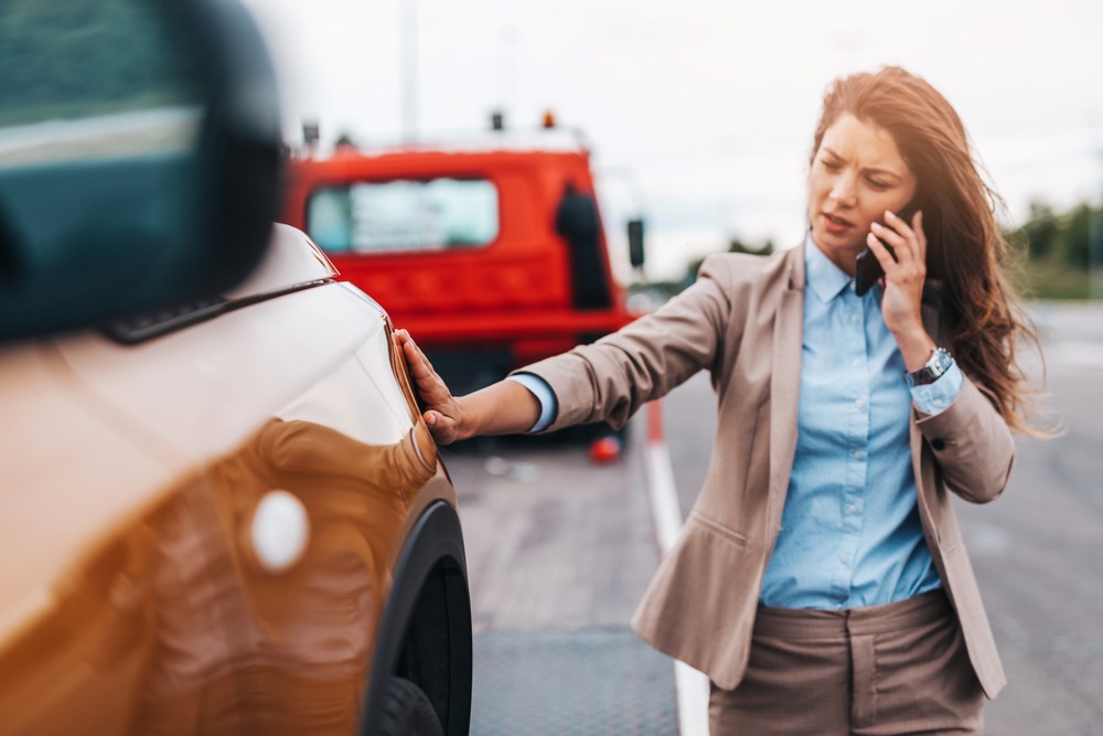 A woman on the phone after a car accident. Are car accident settlements taxable in North Carolina? 