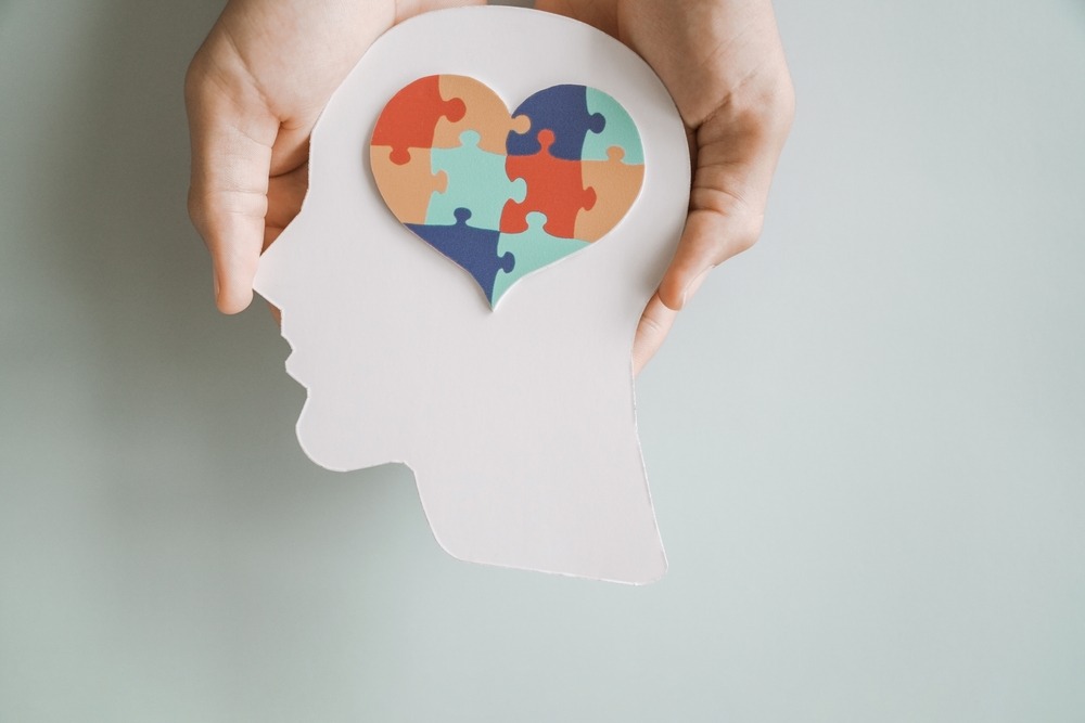 a cutout of puzzle pieces inside a head, representing autism. Is autism a disability?