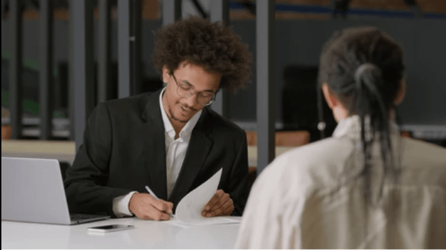 Two businessmen review and sign paperwork during a meeting about an insurance settlement agreement in North Carolina.